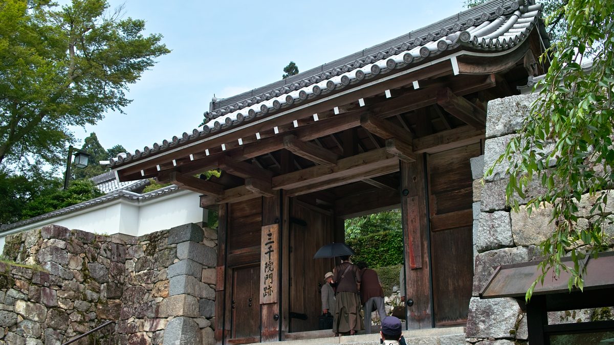 The wooden Goten-mon gate of Sanzen-in temple in Ohara, above a stone retaining wall